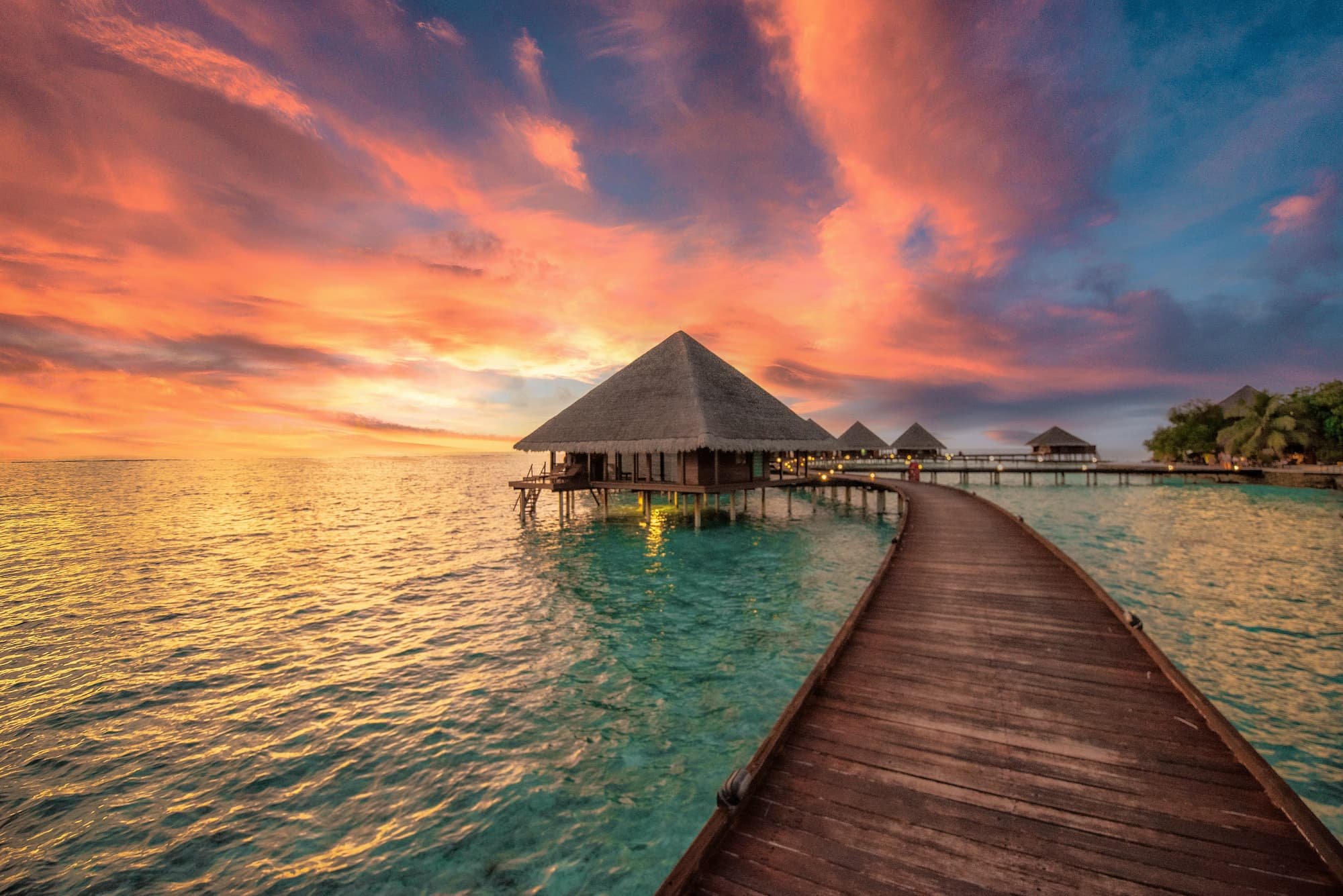 dock leading to an overwater bungalow in the ocean