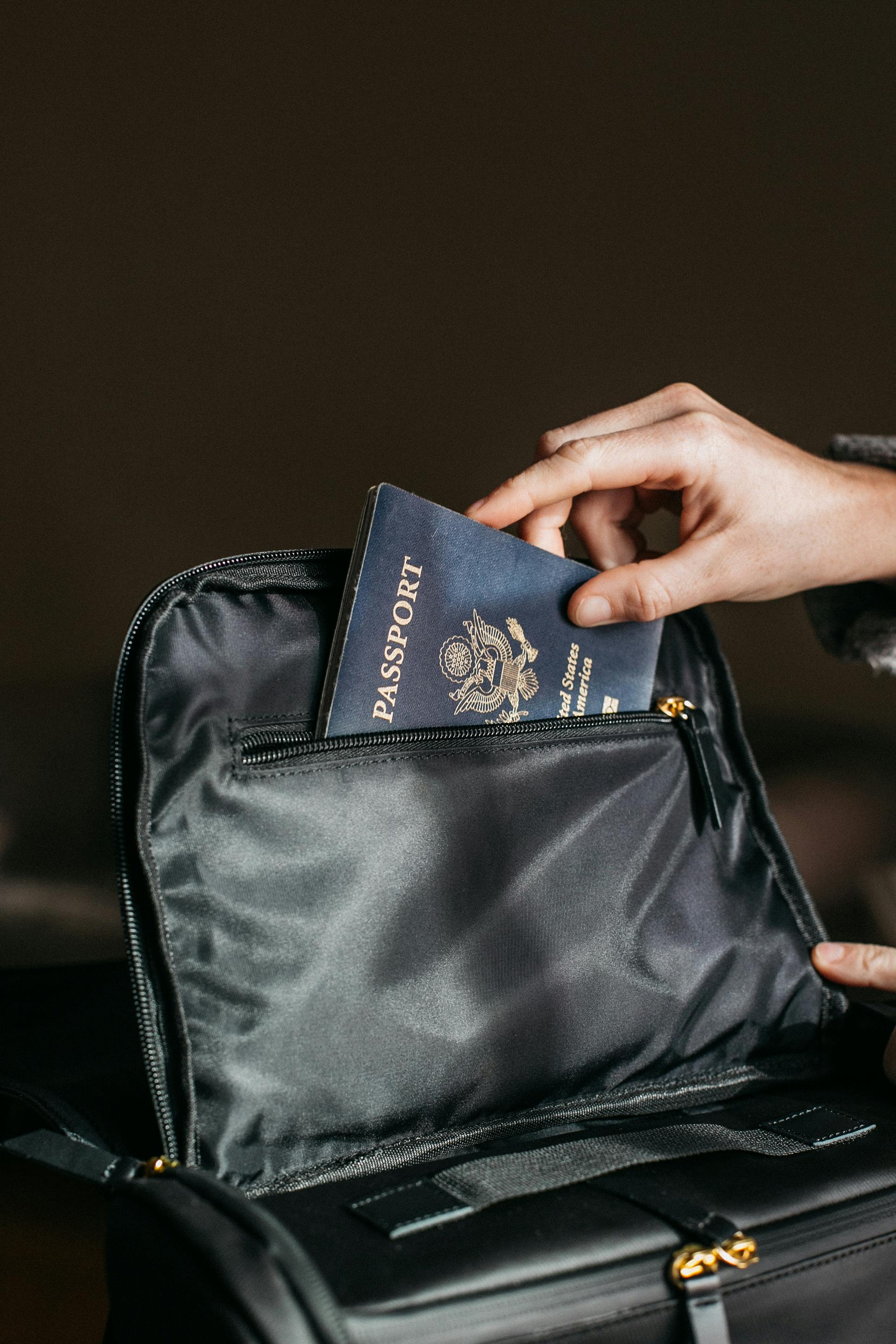 person putting passport in a bag