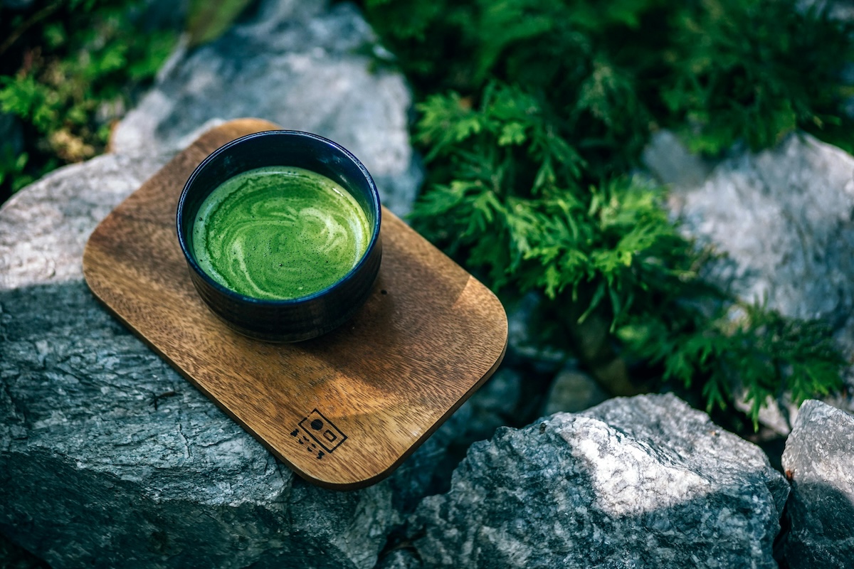 a cup of green tea on a cutting board