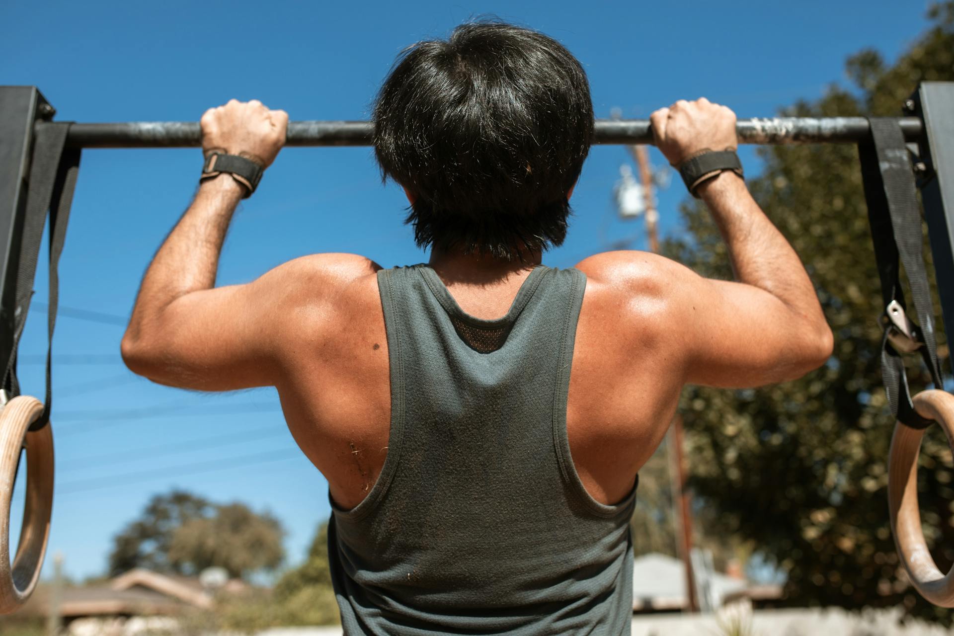 Man doing pullups pull-ups exercise on bar outside