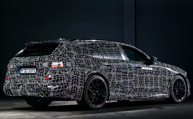 2025 BMW M5 Touring right side three-quarter view of a camoflaged European model.