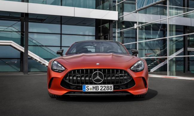 2025 Mercedes-AMG GT 63 S E Performance direct front view parked in front of a glass-walled building.