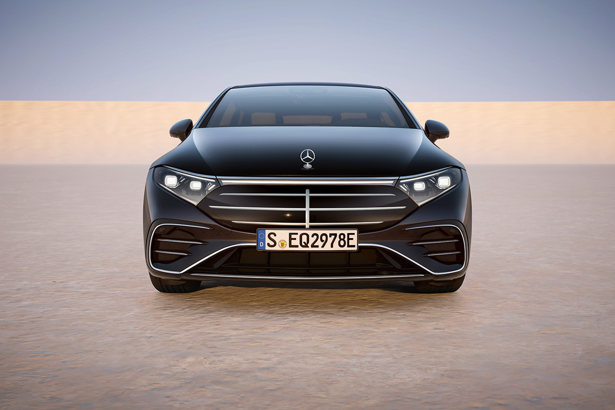 2025 Mercedes-Benz EQS in Obsidian Black front facing with European plates on a tan surface with a medium blue background.