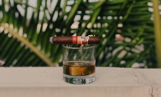 AVO Synchro cigar resting on top of filled whiskey glass.