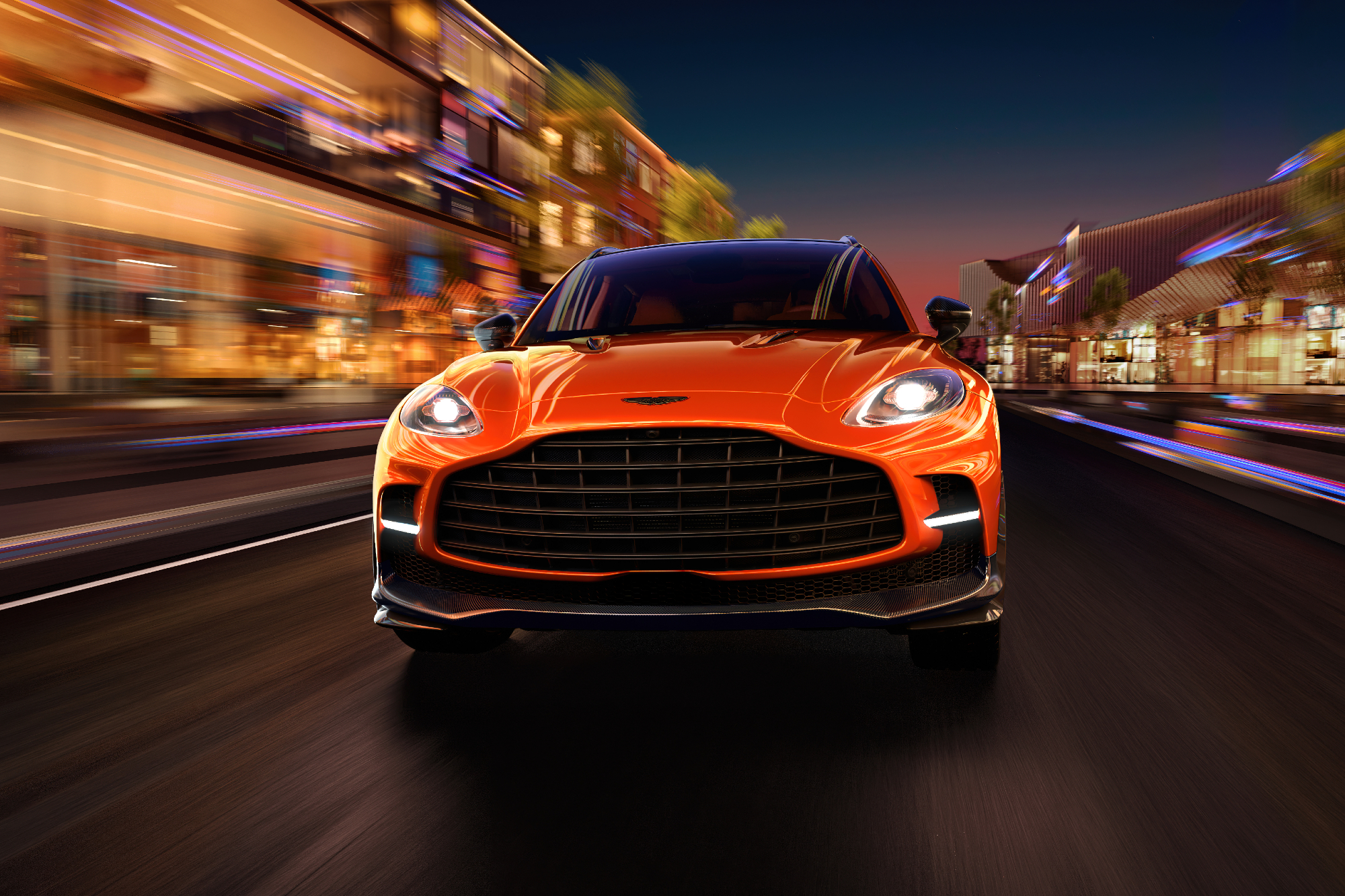 Aston Martin DBX707 on a city street with blurred lighting as car drives directly toward the camera.