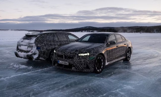 Camoflaged 2025 BMW M5 Sedan and M5 Touring European models parked side by side on ice on a huge body of water.