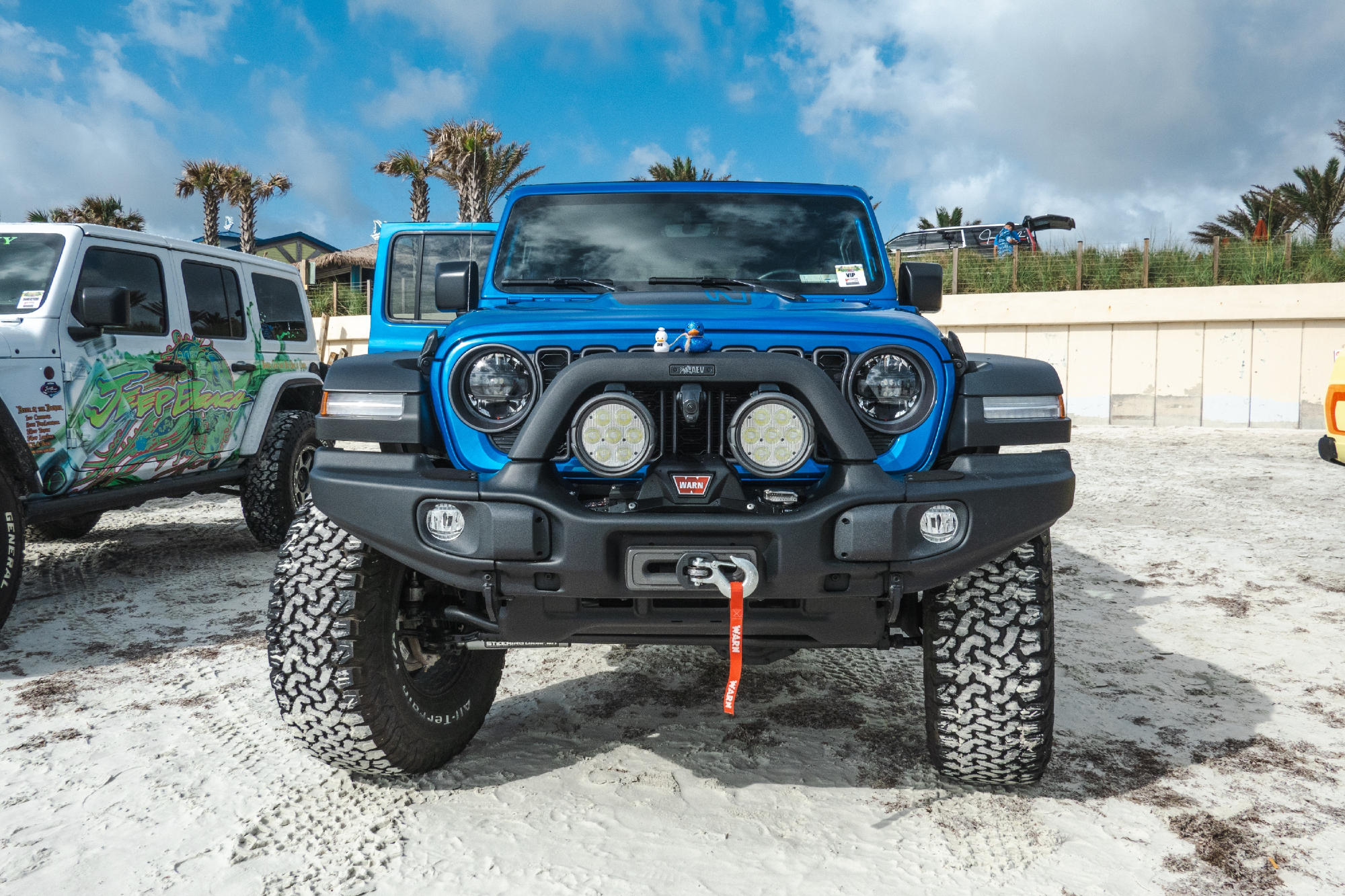 Photo from Jeep Beach Week 2023 featuring the front of a blue Wrangler set up with off-road bumper, winch, and other options.