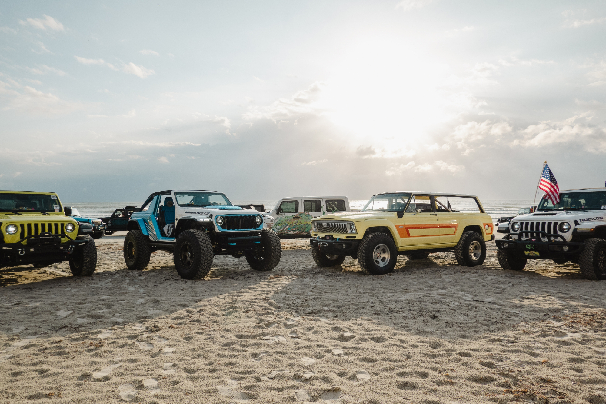 Photo from Jeep Beach Week 2023 with a line up of various Jeep models and vintages.