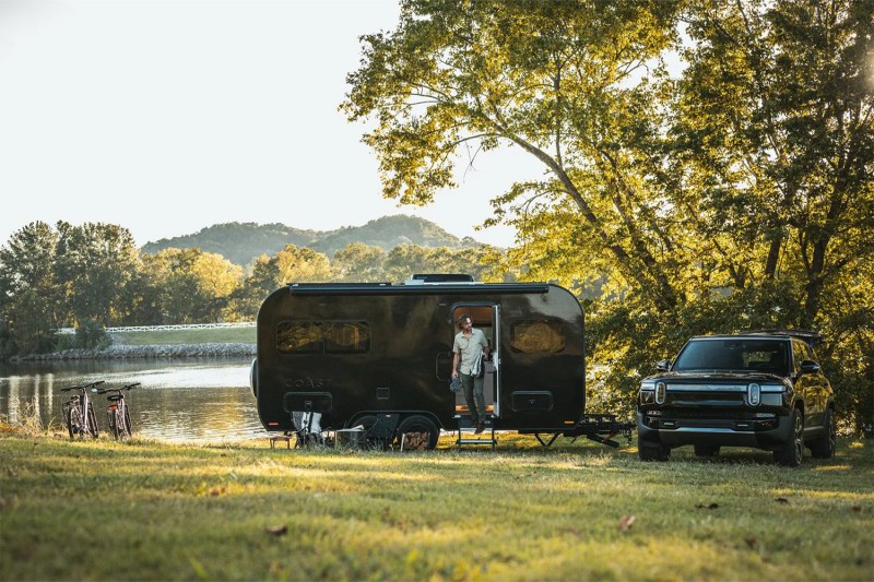 Coast Model 1 solar electric travel trailer/RV parked near a pond.