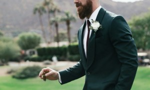 Man in a tux at a wedding holding a lit cigar
