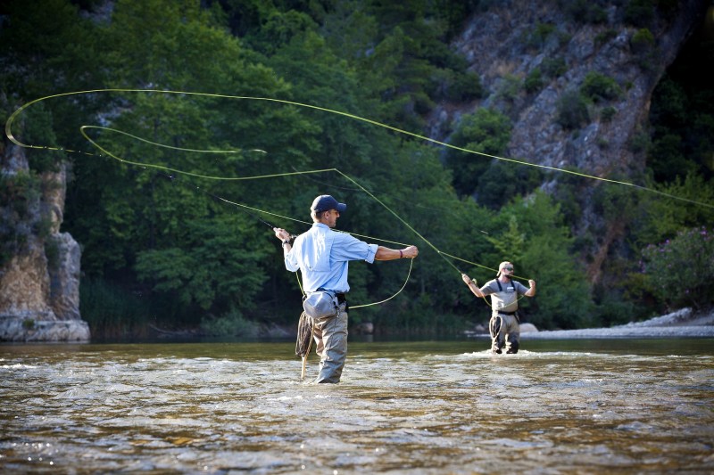 Two men fly-fishing in a river.