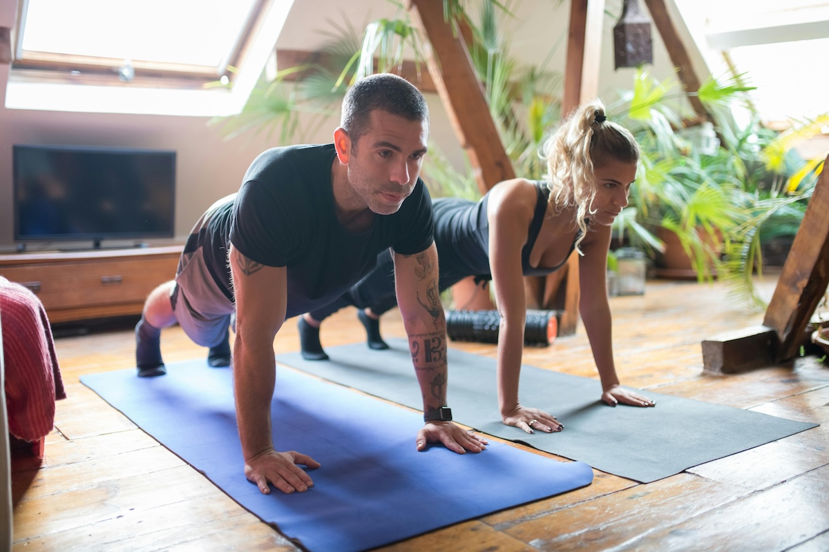 man and woman doing planks studio fitness class