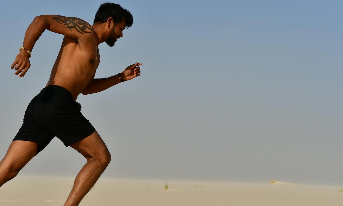 a close up of a shirtless man running outside