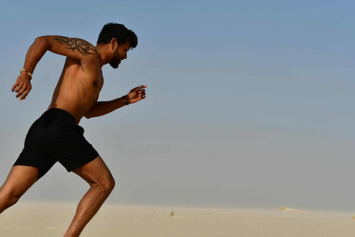 a close up of a shirtless man running outside