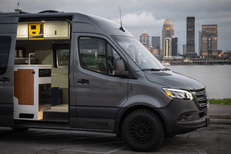 Side view of a Remote Vans camper van with its sliding door open.