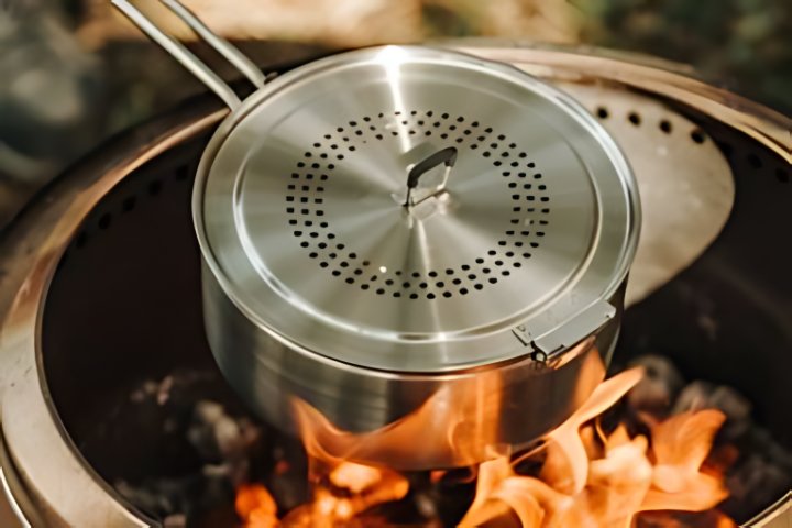 A solo stove popcorn maker placed over a solo stove standalone fire pit