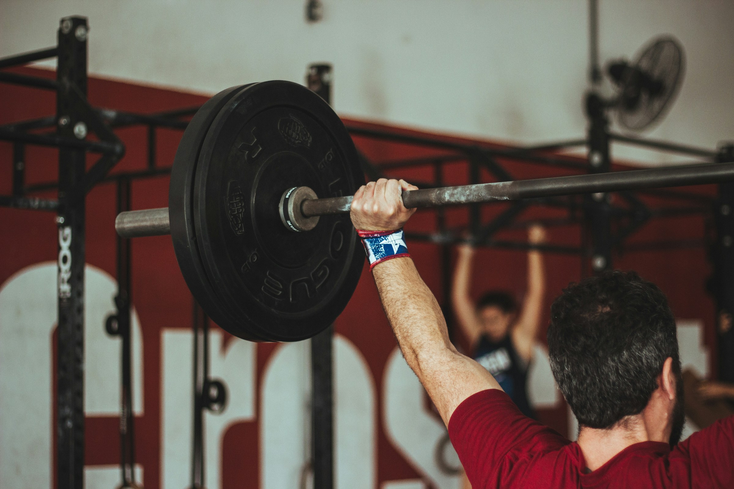 push press exercise man lifting weight over head in gym