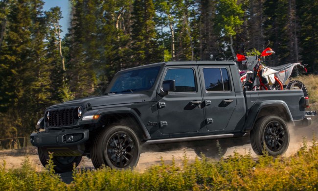 2024 Jeep Gladiator Nighthawk limited edition of 200 driving on a dirt road in a forest,