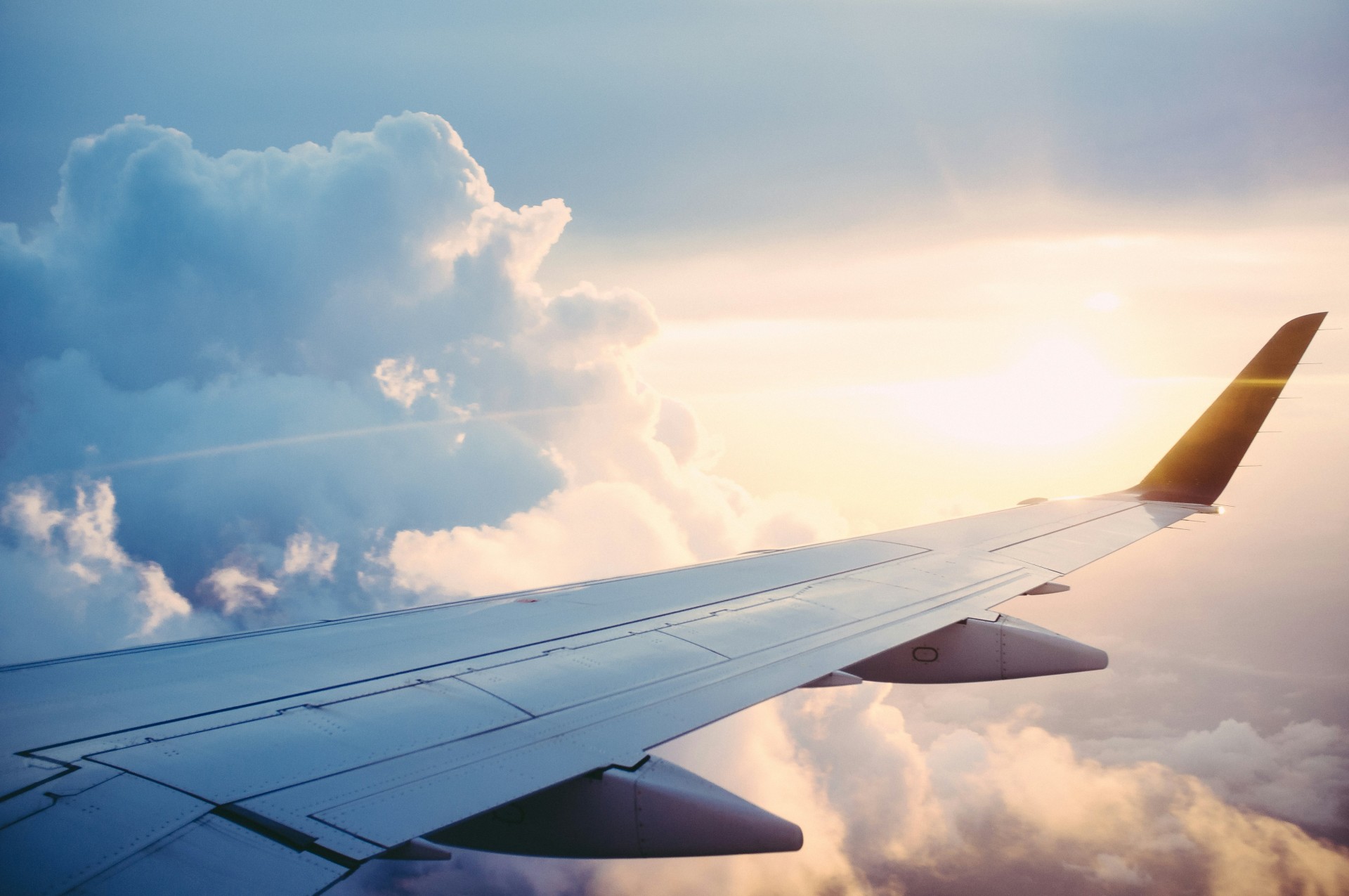 Sun and clouds with airplane wing