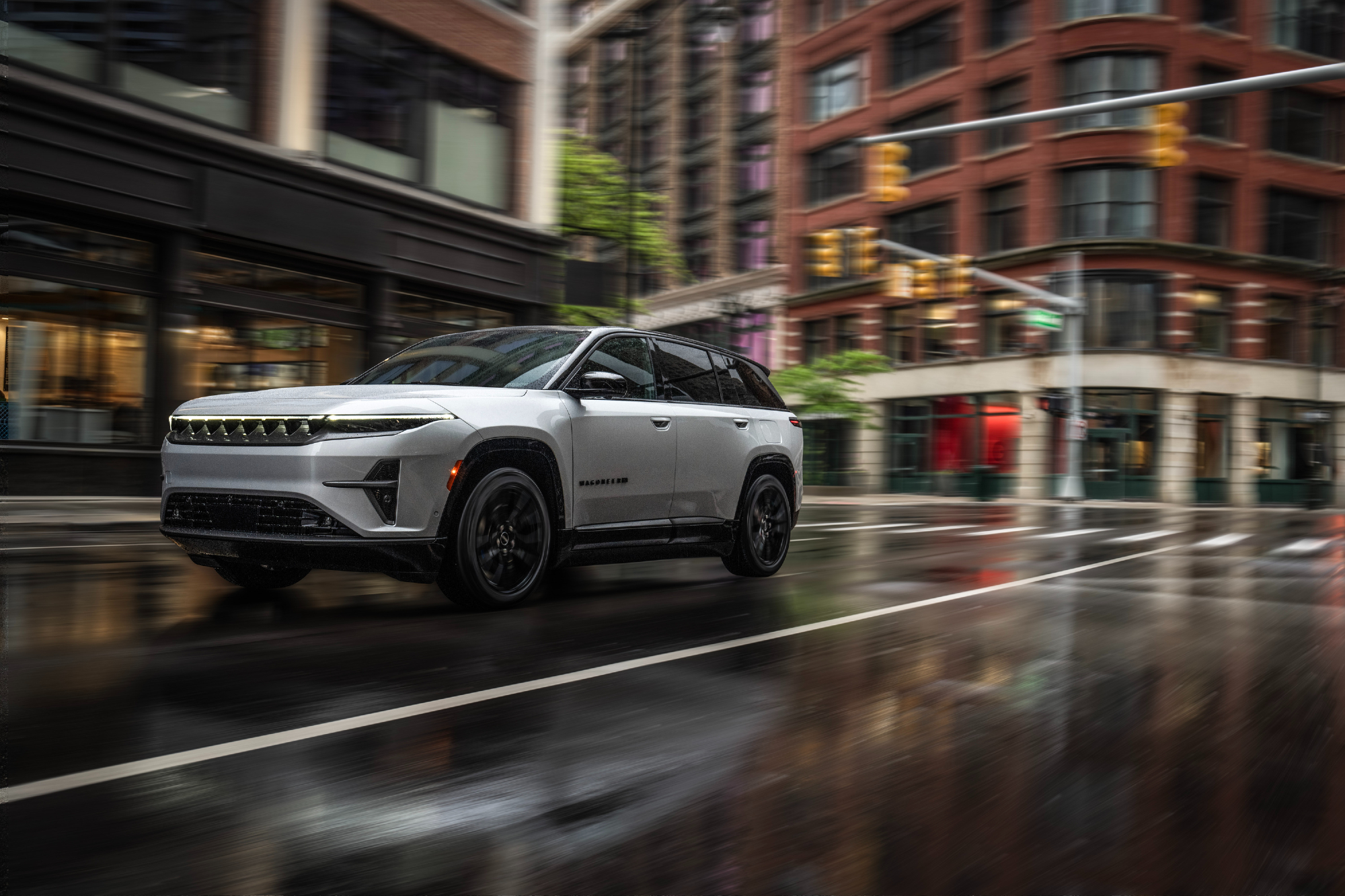 Jeep Wagoneer S Launch Edition driving on a rainy wet city street.