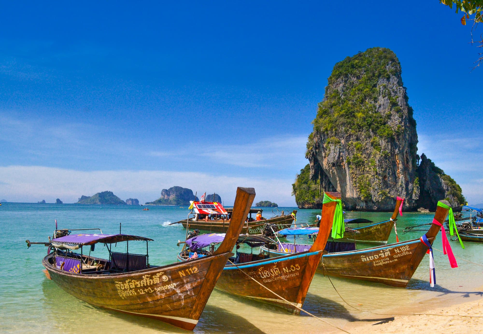 five brown wooden boats in Thailand