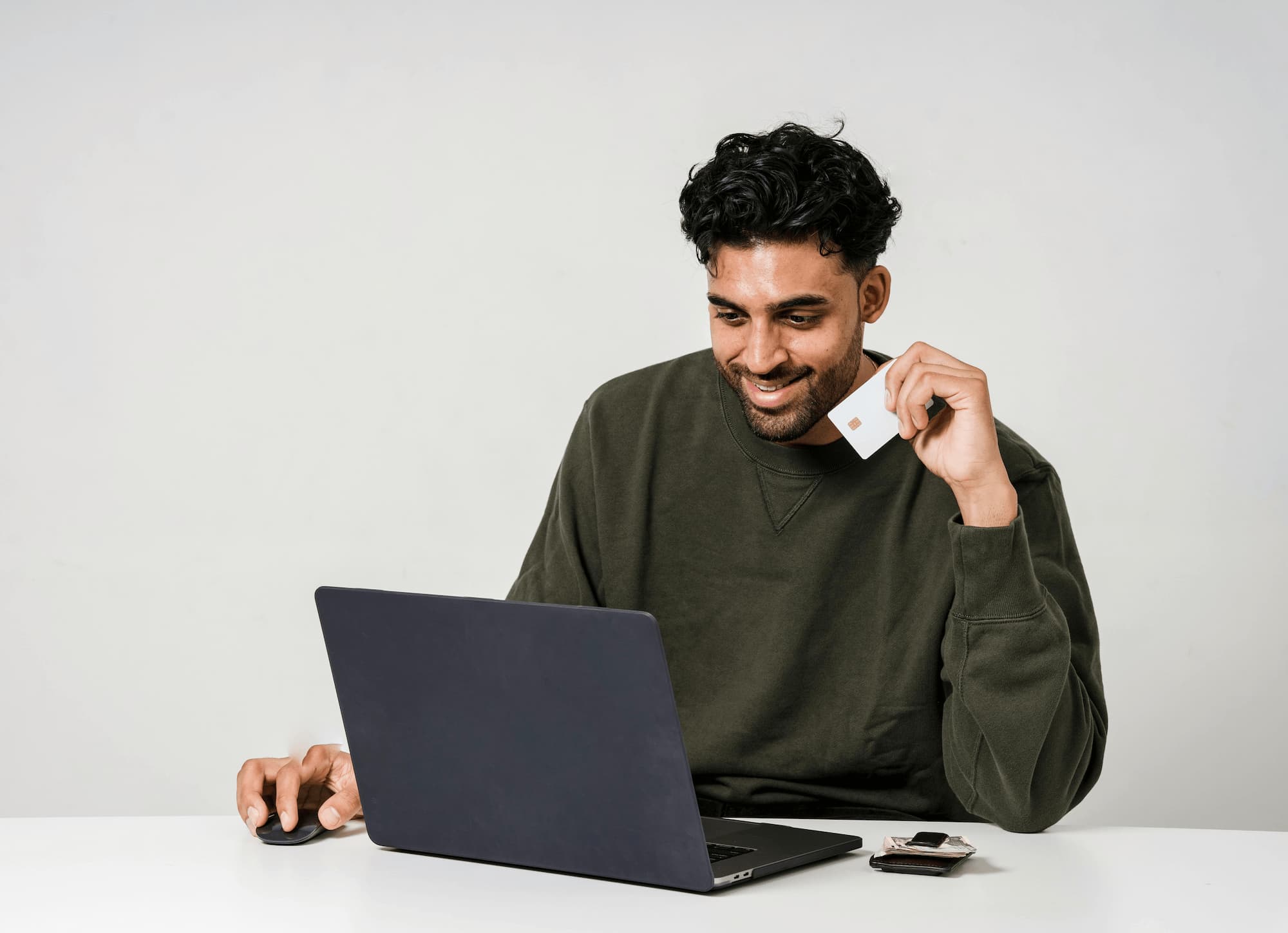 man holding credit card looking at computer