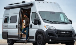Man stepping out of a Noovo Plus camper van parked near the beach.