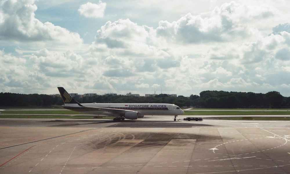 An airplane on the runway under a cloudy sky