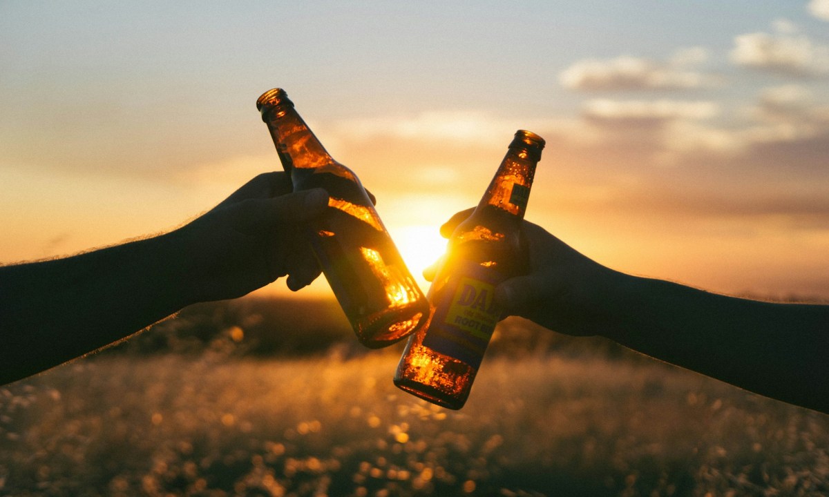 Cheers beer bottles with sun in the background