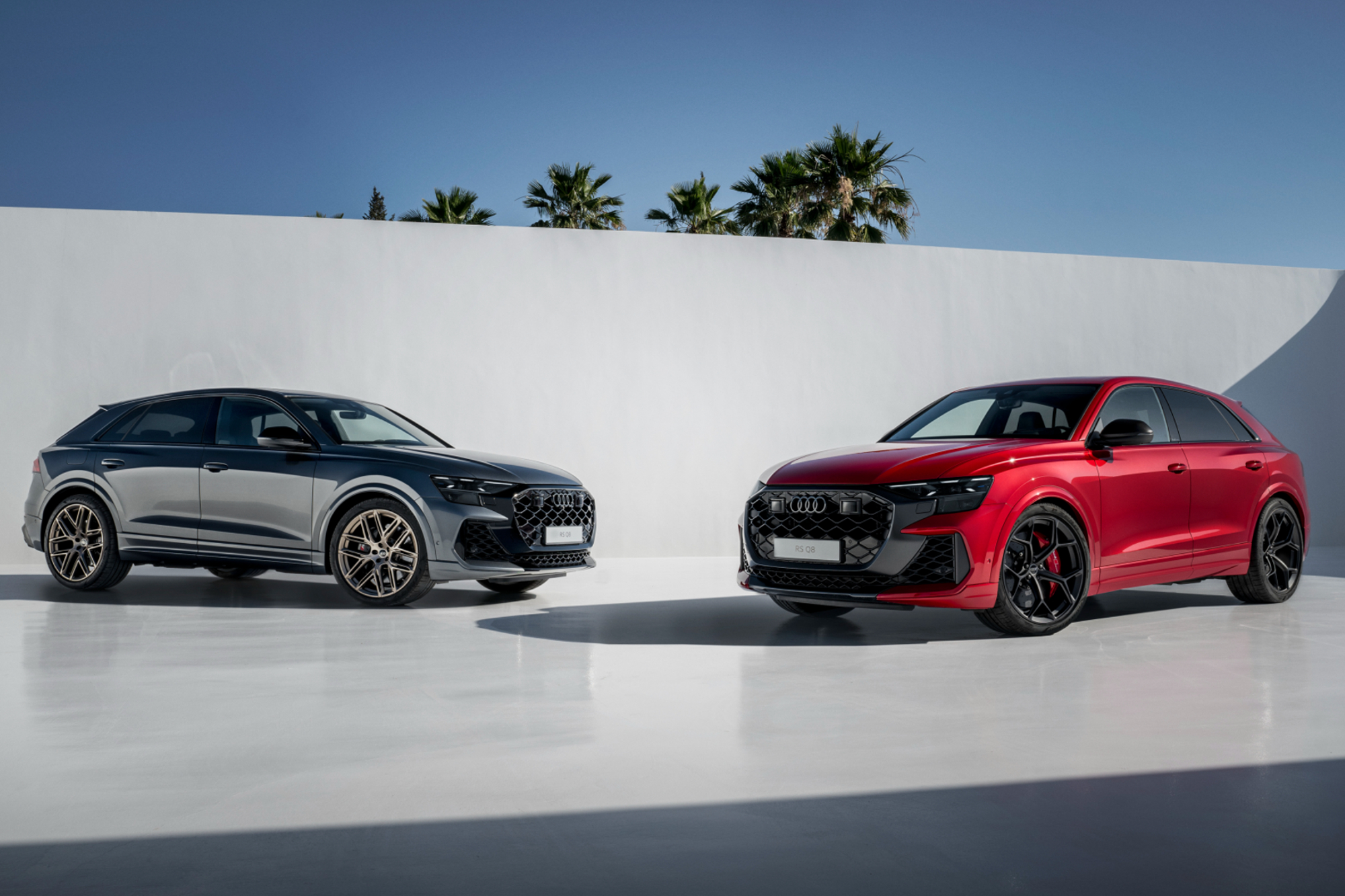 2025 Audi Q8 RS and Audi Q8 RS Performance parked white concrete surface with white walls.