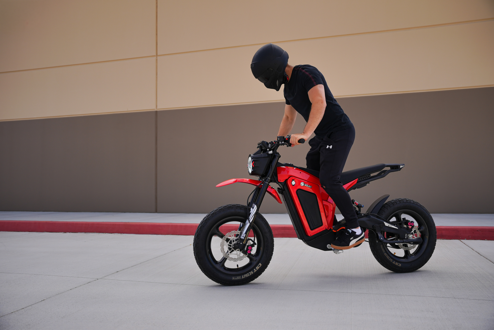 Solar Eclipse Race Edition electric motorcycle with a rider balancing on the pegs fully stopped