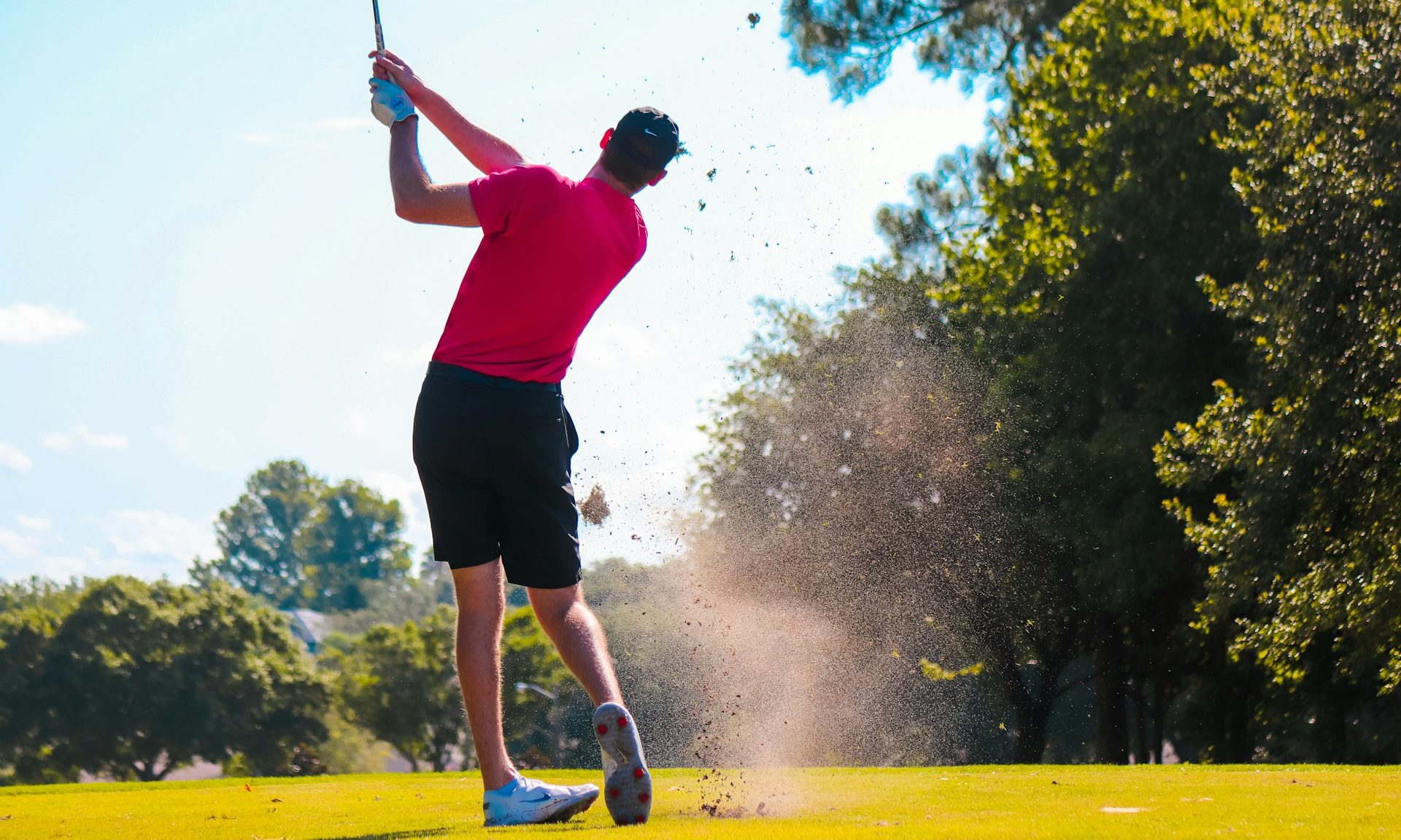 A person taking a swing on the golf course.