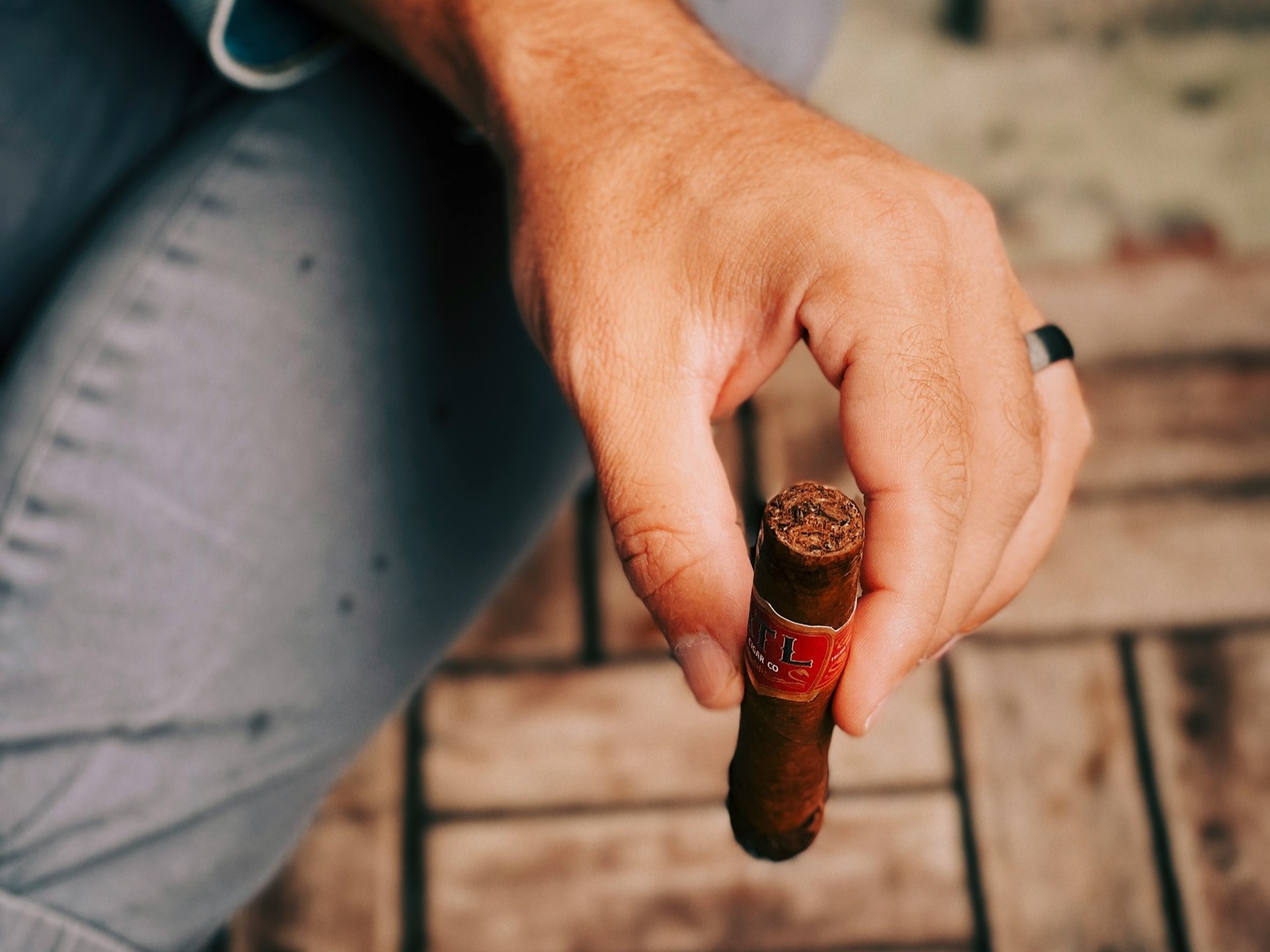 Man holding lit cigar relaxing.