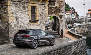 2025 Audi SQ6 e-tron European model parked on a stone street near a seaport.