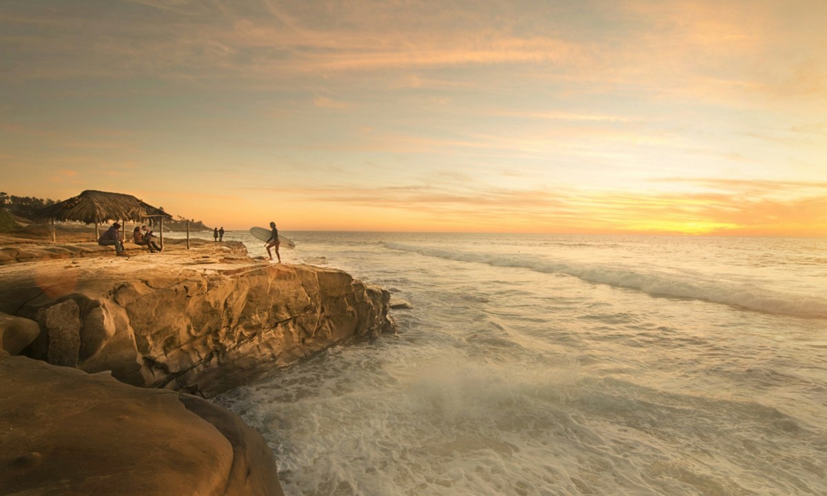 Surfer on cliffs, California