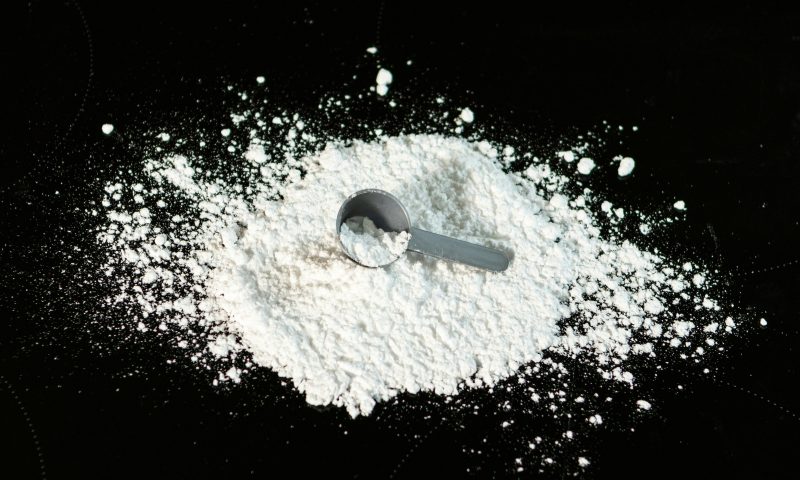 Spilled creatine with a scoop spoon