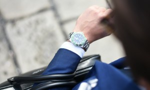 Man looking down at silver watch