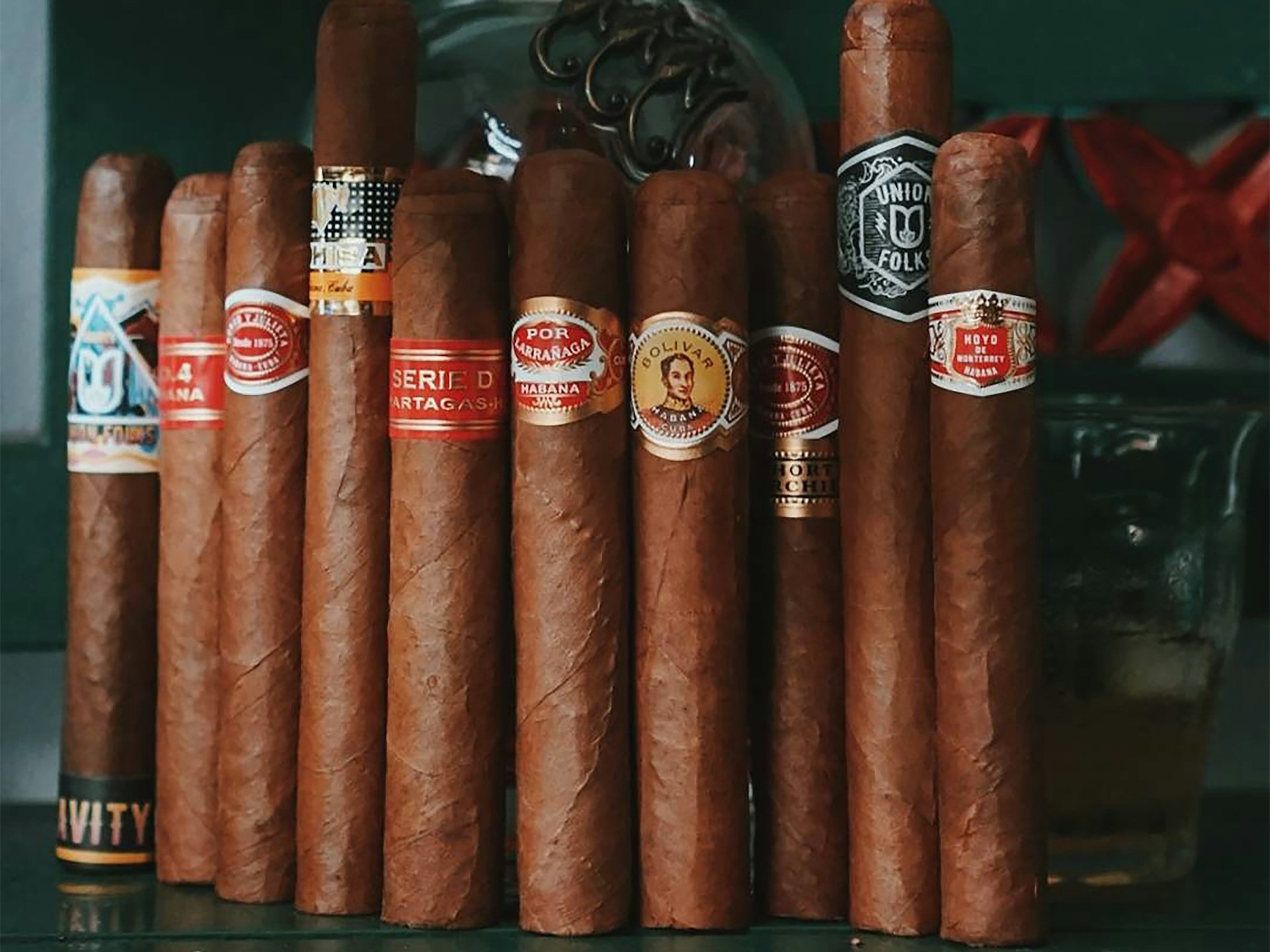 Cuban cigar bundle on desktop in full display with decanter.