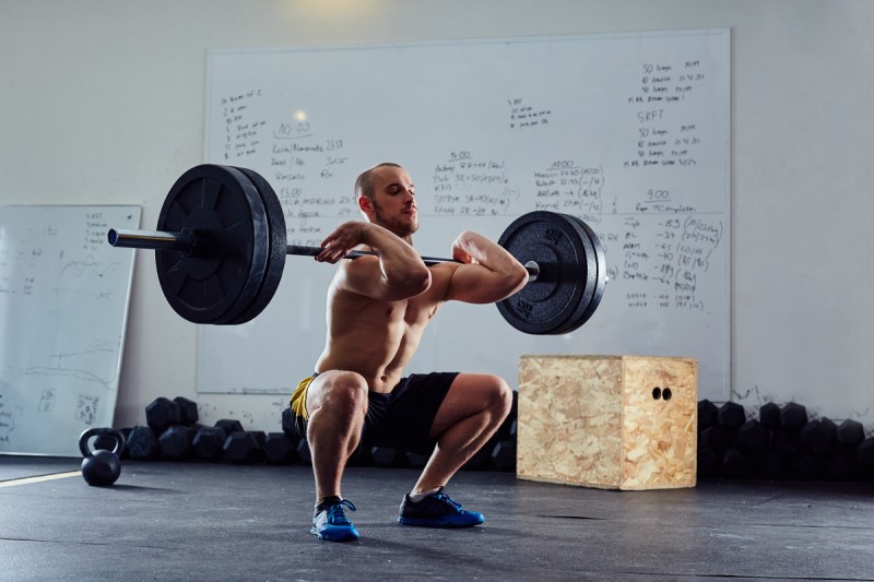 Man doing front squats shirtless