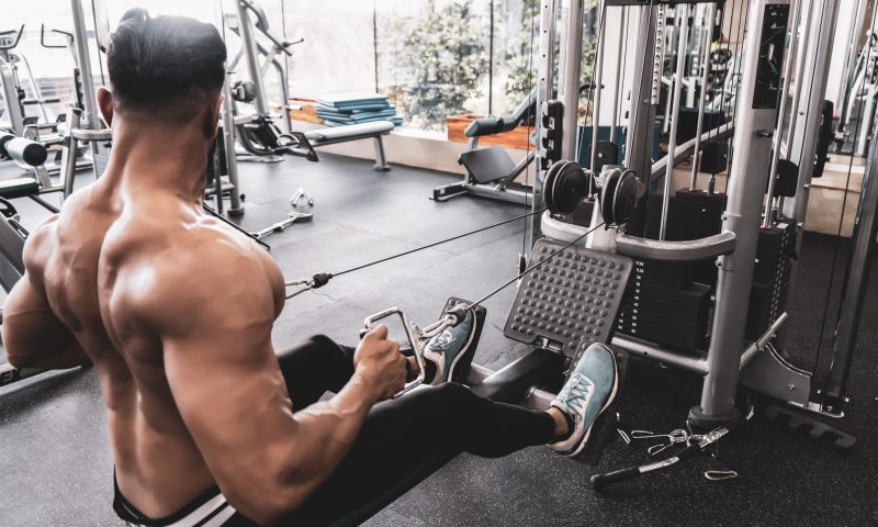 Athlete makes low cable pulley row seated in gym.