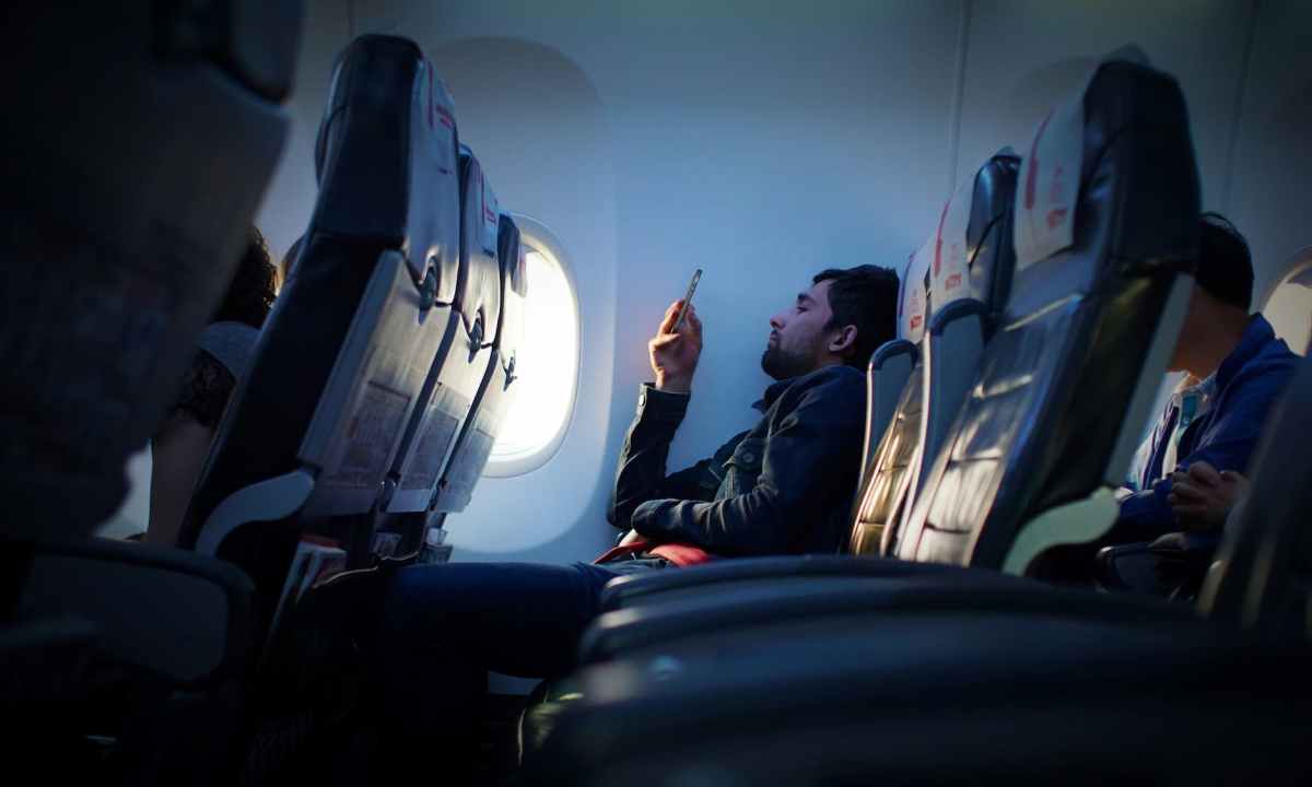 Person sitting inside an airplane using a phone