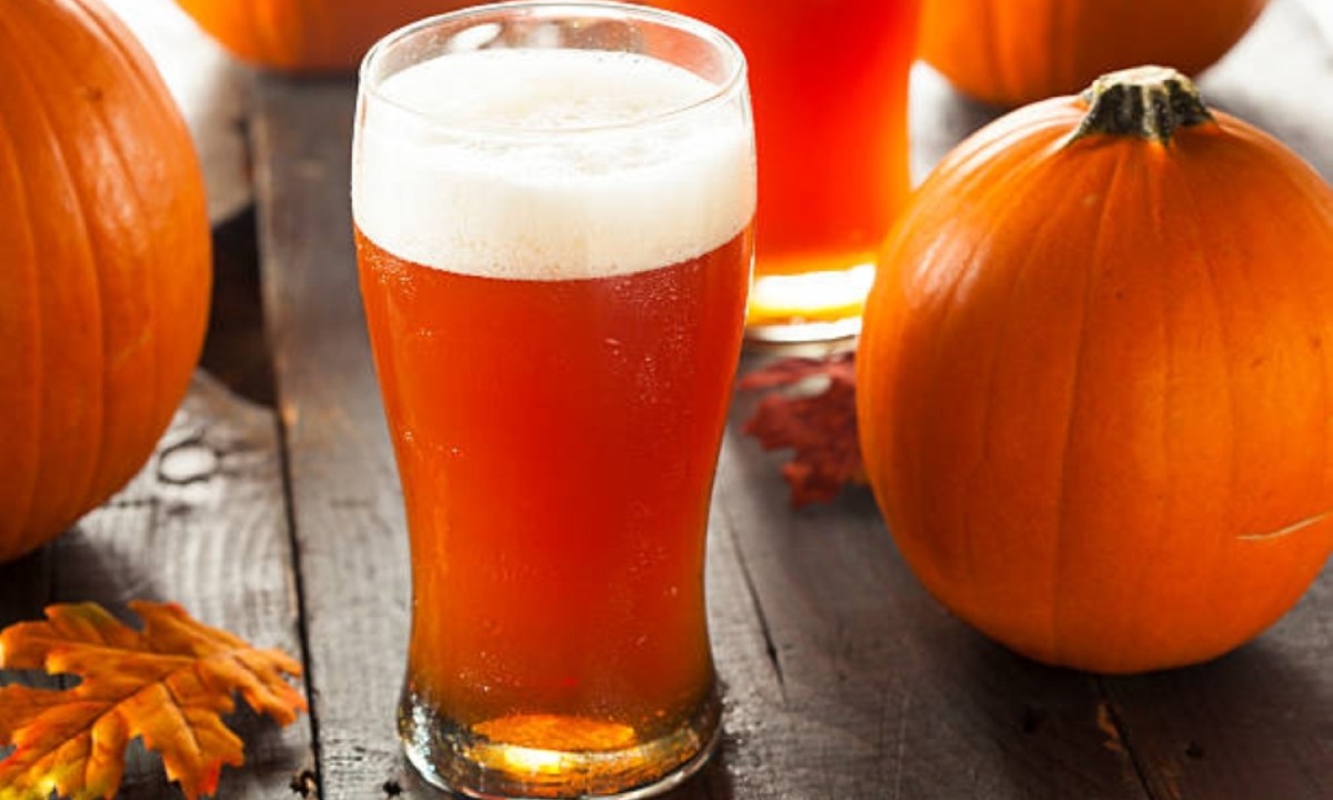 Pumpkin beer next to pumpkins