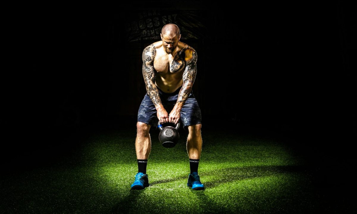 man swinging kettlebell with shorts blue shoes black background kettlebell swing pexels