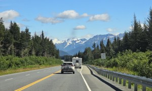 A road leading to Alaska with mountains in the background