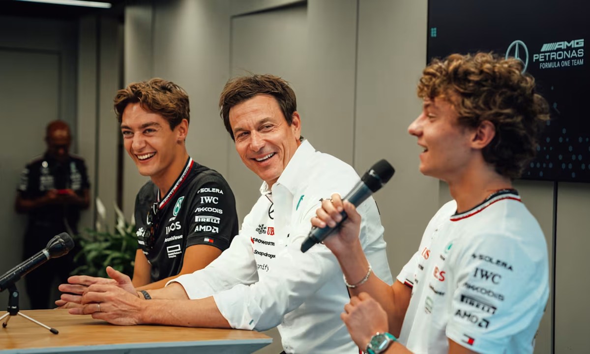 Mercedes F1 driver George Russell, Team Principal Toto Wolf, and new driver Kimi Antonelli seated at a press conference.