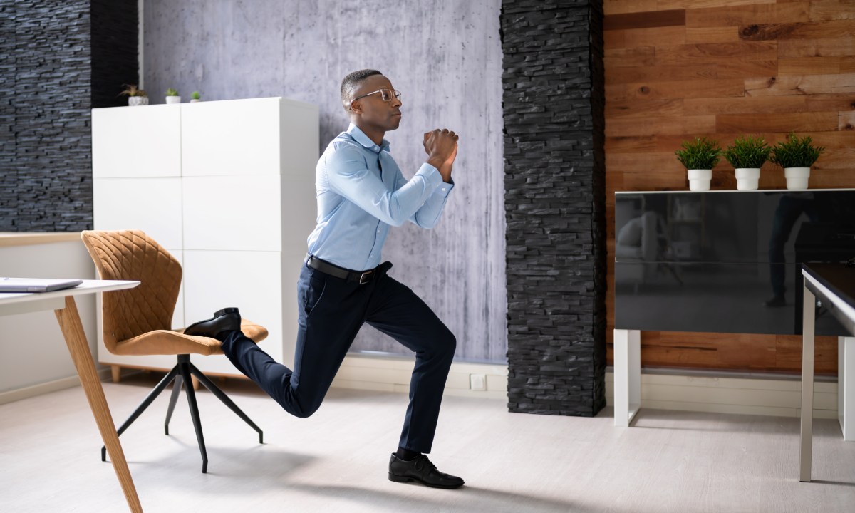 Man exercising in the office at work Bulgarian split squat