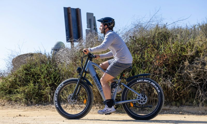 man riding bike bicycle with helmet on cycling outdoors blue sky