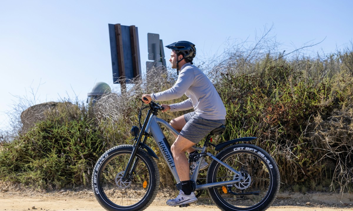man riding bike bicycle with helmet on cycling outdoors blue sky