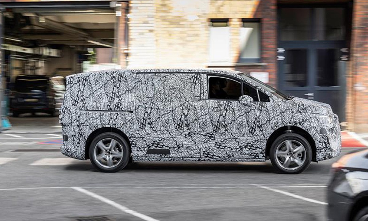 A Mercedes-Benz VAN.EA electric van covered in heavy vehicle camouflage.