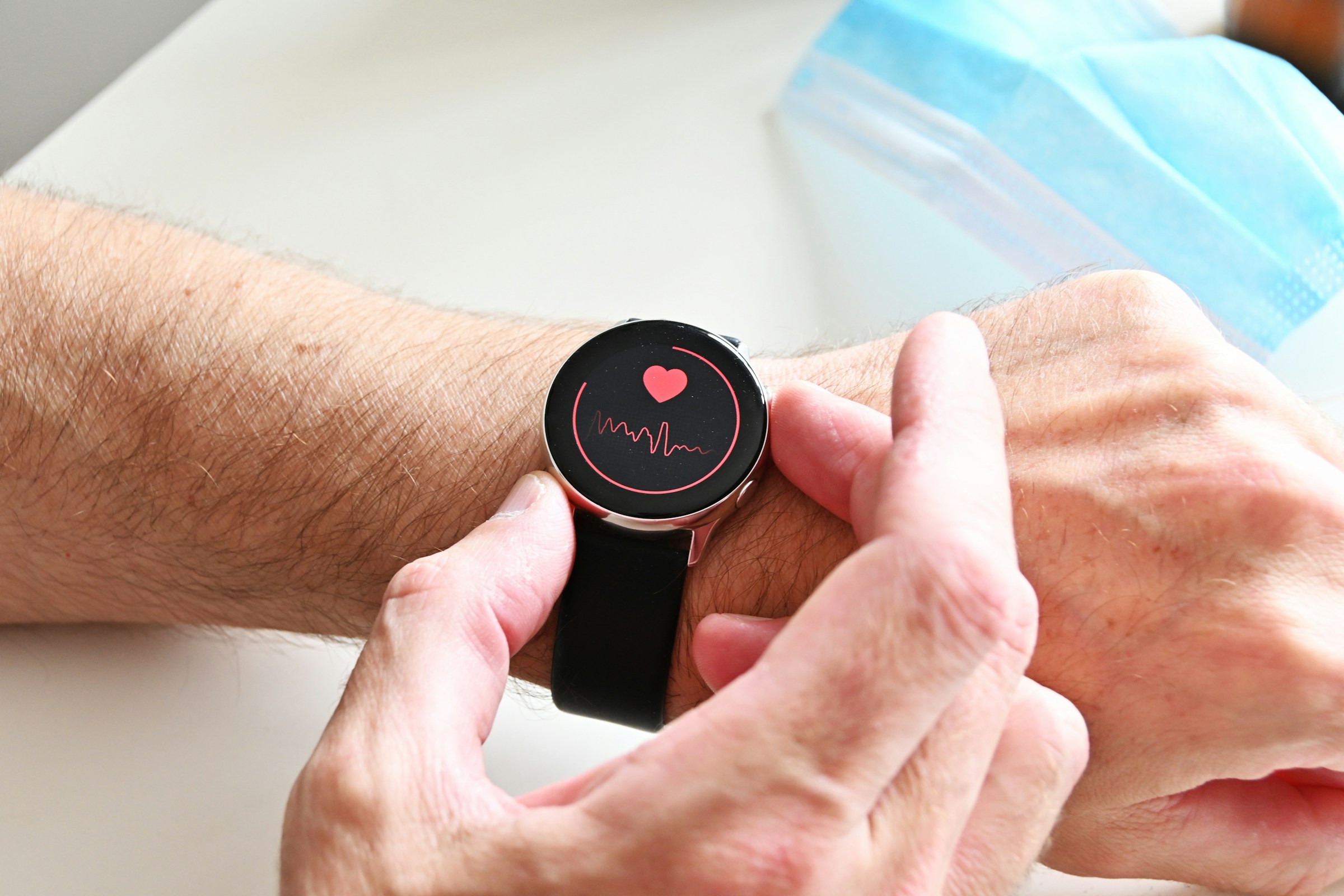 Primer plano del brazo del hombre con el reloj que comprueba la frecuencia cardíaca la salud del corazón pulso